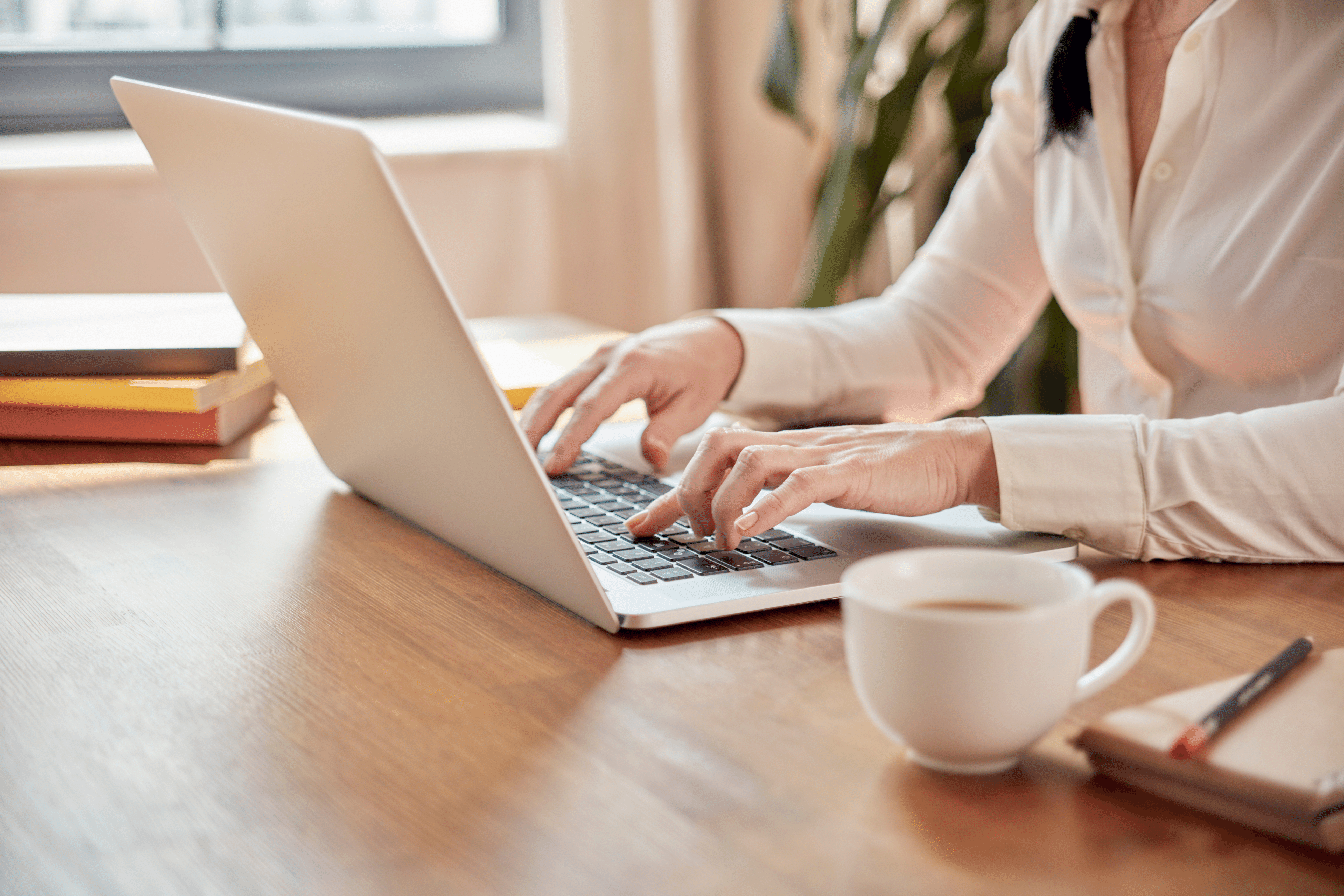 A woman typing on a laptop and creating content