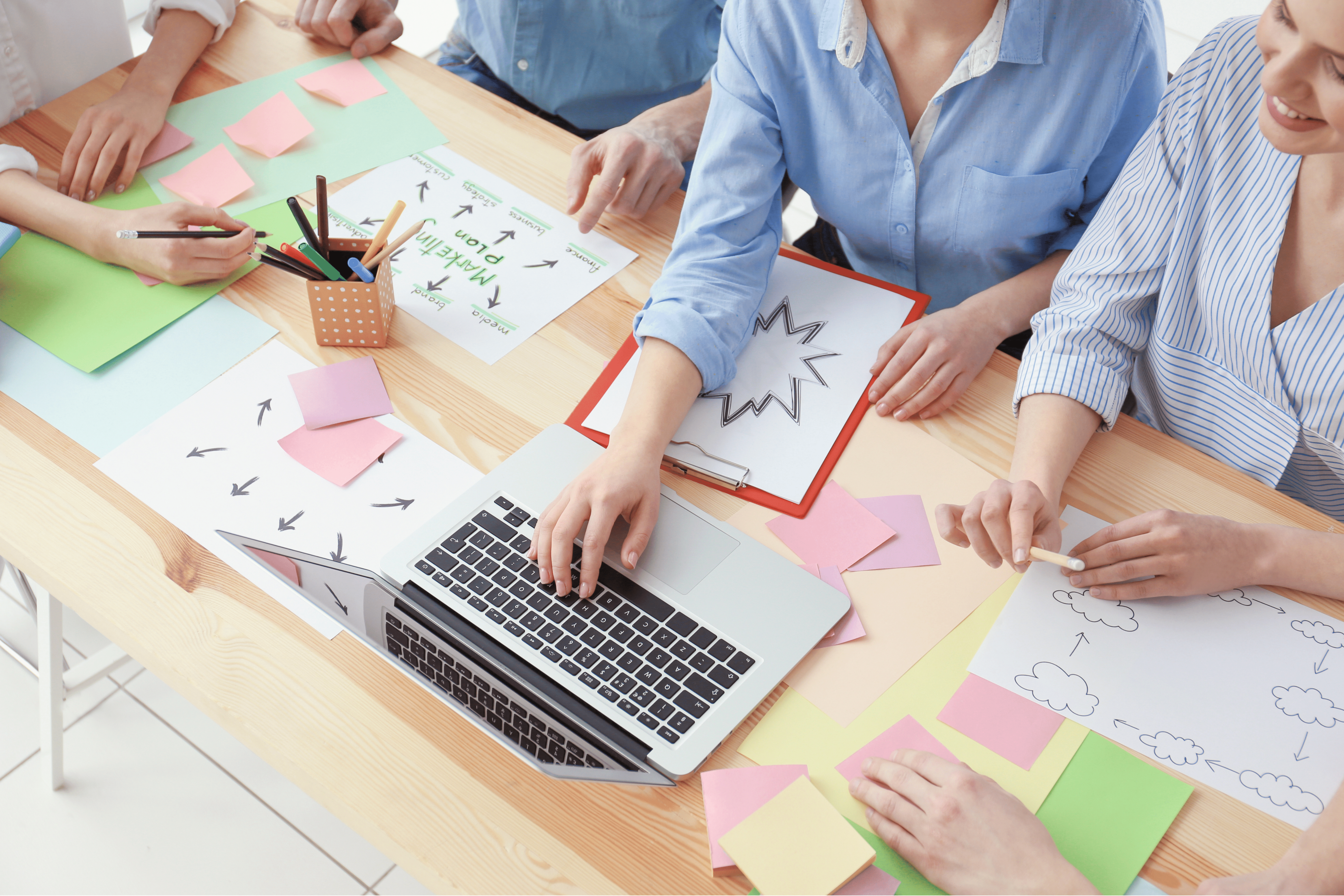 A marketing team gathered around a laptop